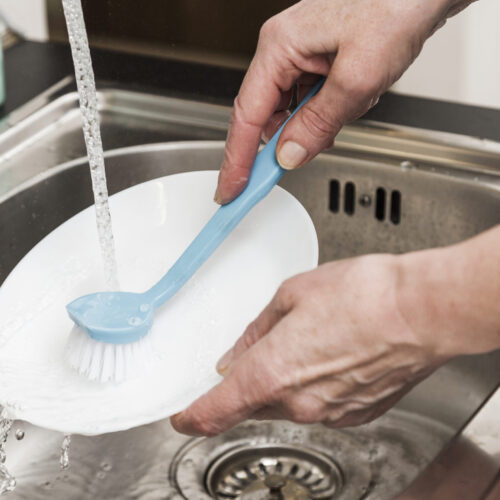 high-angle-woman-washing-plate